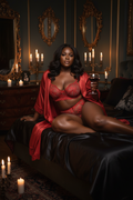 Noir Rouge Signature lifestyle editorial - model in candlelit luxury bedroom